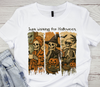 Flat lay of a white t-shirt with a ready-to-press "Just Waiting for Halloween" skeleton trio DTF transfer.