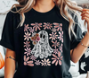Close-up of a model wearing a black t-shirt with a lace ghost DTF transfer holding daisies, surrounded by retro floral art.