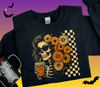 Black sweatshirt with skeleton design holding a drink, surrounded by flowers on a gradient background.